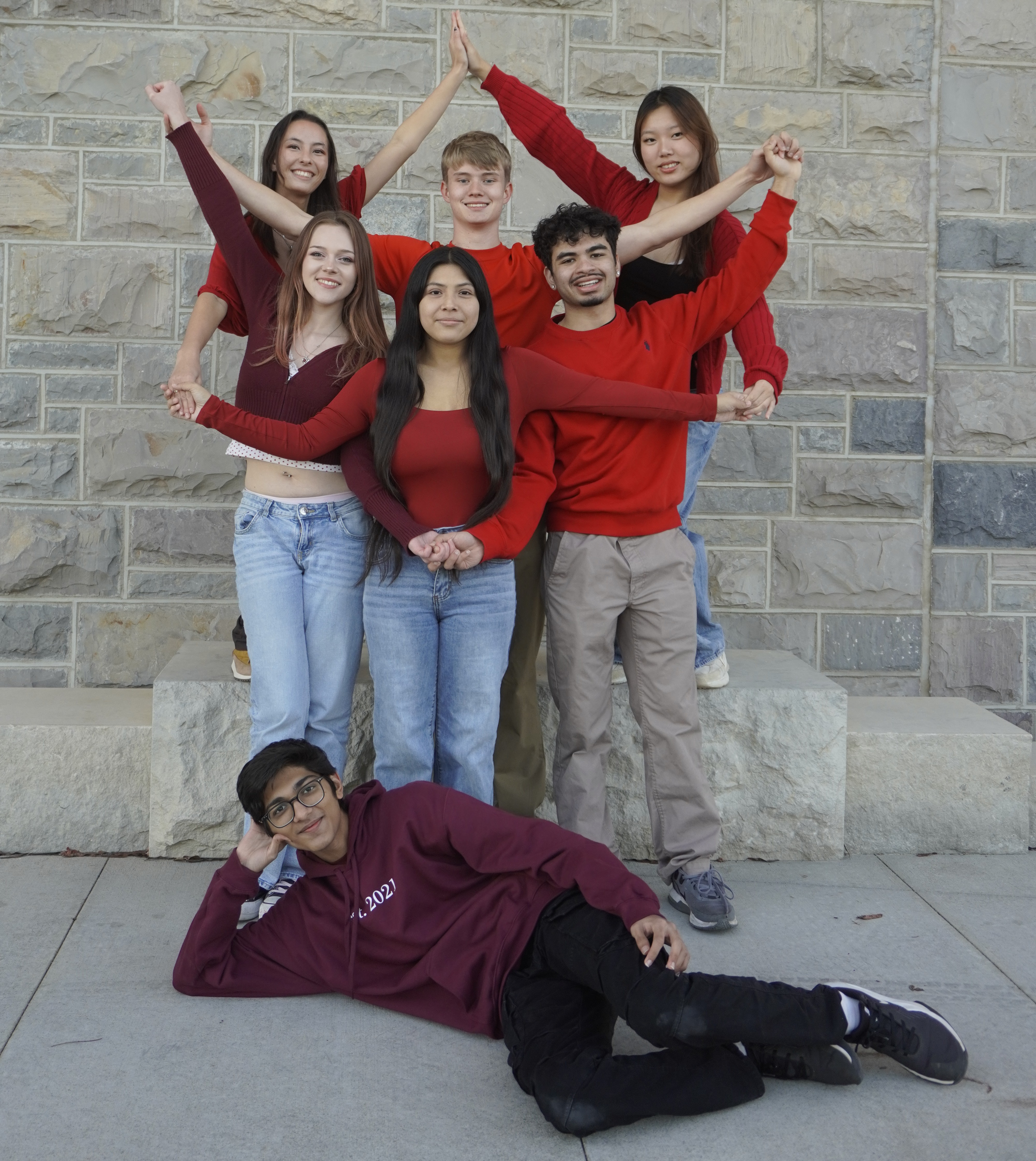 Six team members creating a star formation with seventh member laying down in front