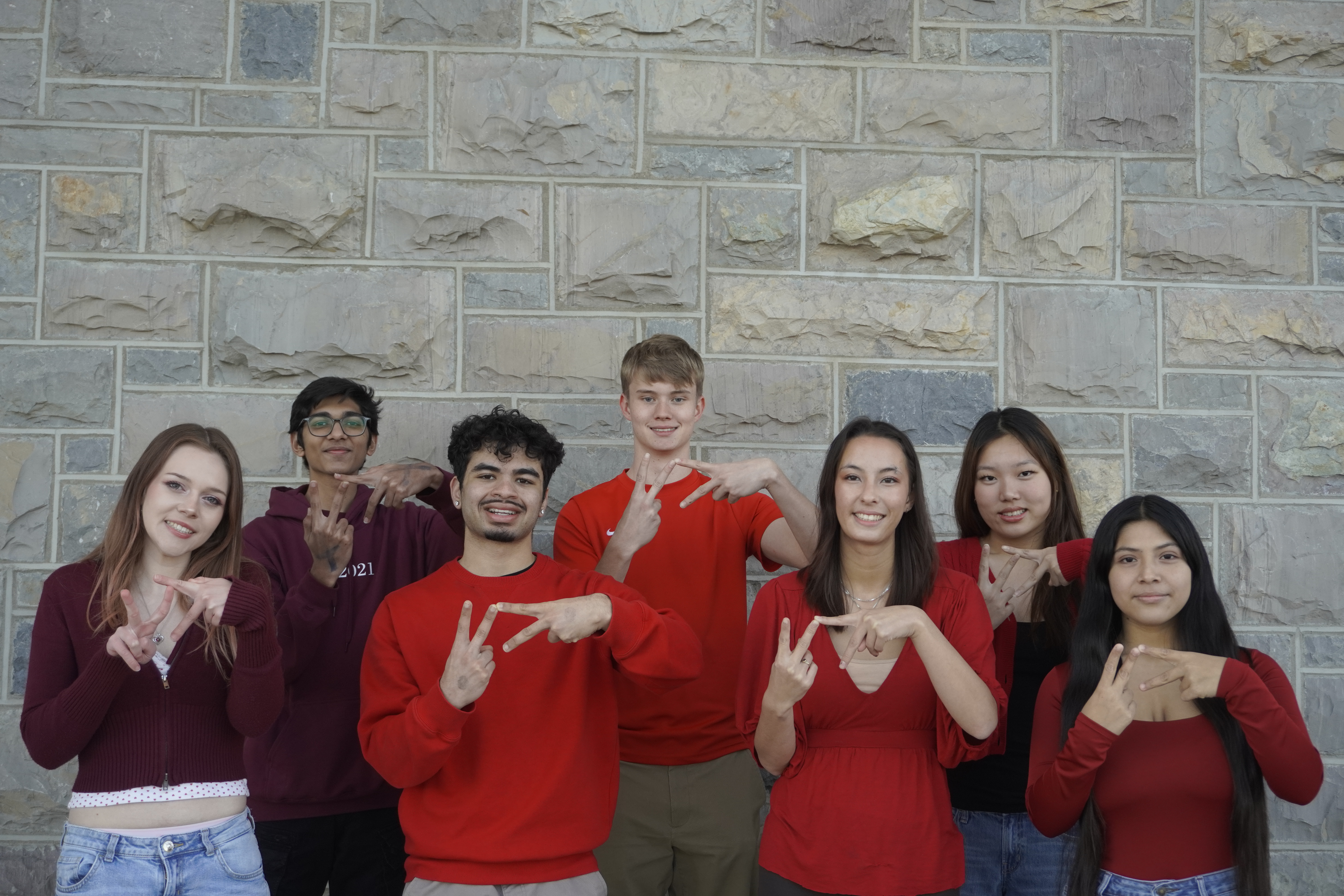 Seven team members making hand gesture of VT